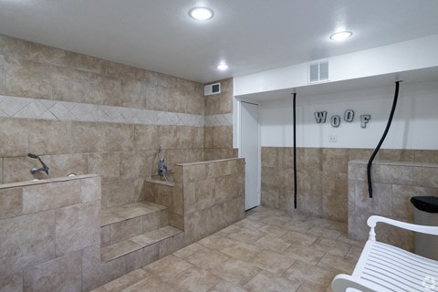 A bathroom with a tiled shower and a bench.