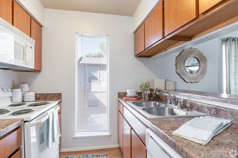 A kitchen with a white stove top oven and a white microwave.
