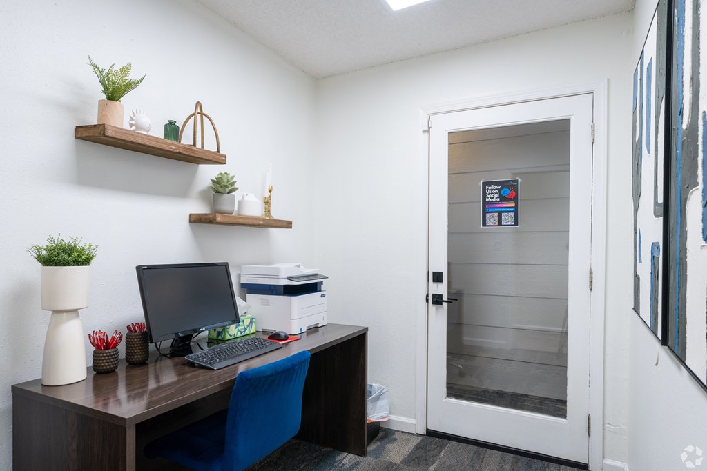 A small office with a desk, chair, and a laptop.