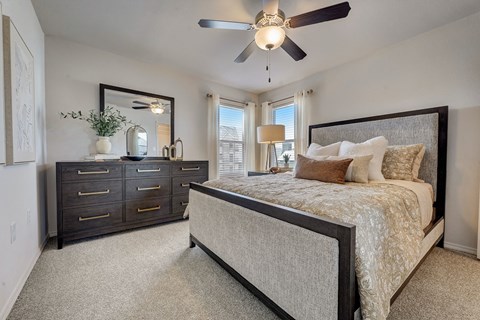 a bedroom with a bed and a ceiling fan
