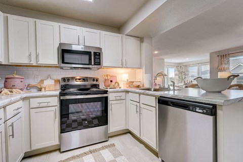 a kitchen with white cabinets and stainless steel appliances