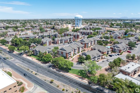 A water tower stands tall in the distance behind a residential area.