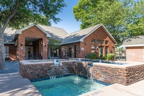 A brick house with a pool in the backyard.