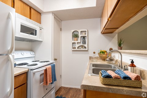 A kitchen with a white refrigerator, white stove, and a white oven.