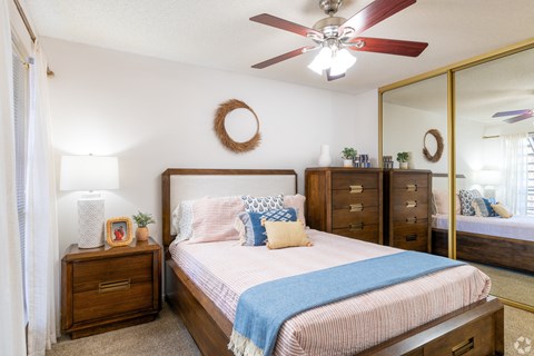 A bedroom with a bed, dresser, and mirror.