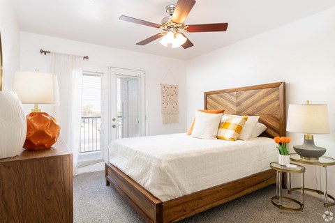 A bedroom with a bed, nightstands, and a ceiling fan.