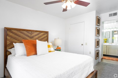 A bedroom with a large bed and a ceiling fan.