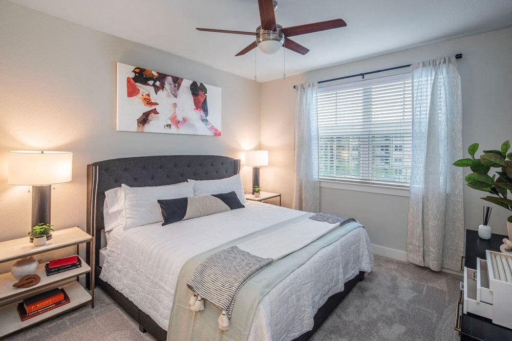 a bedroom with a bed and a ceiling fan