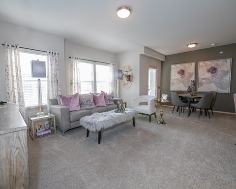A living room with a grey couch, a white armchair, and a grey coffee table.