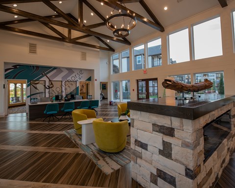 A large room with a stone fireplace and a mural on the wall.