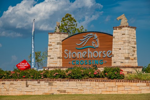 A sign for Stonehorse Crossing with a horse statue on top.