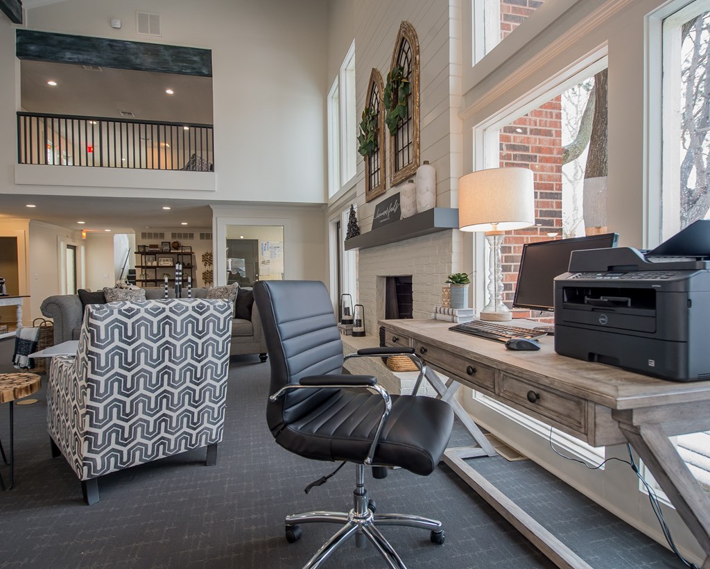 A black and white patterned chair sits in front of a desk with a printer on it.