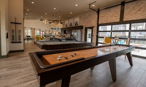 A pool table in a room with a brick wall.