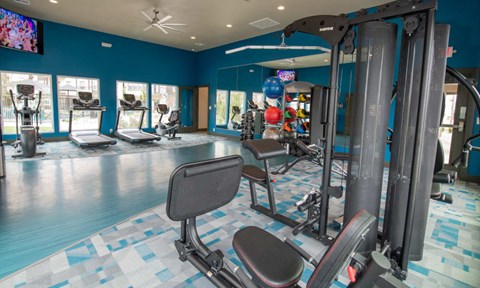 A gym with a variety of equipment including a rowing machine.