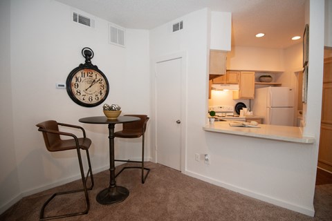A room with a table and two chairs and a clock on the wall.