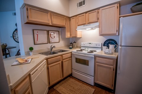 A kitchen with wooden cabinets and white appliances.