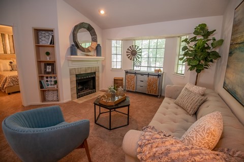 A living room with a fireplace and a blue chair.