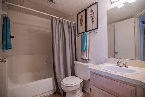 A white toilet sits next to a white sink in a bathroom.