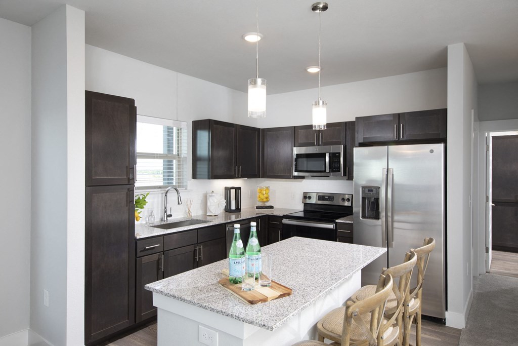 a kitchen with stainless steel appliances and a marble counter top