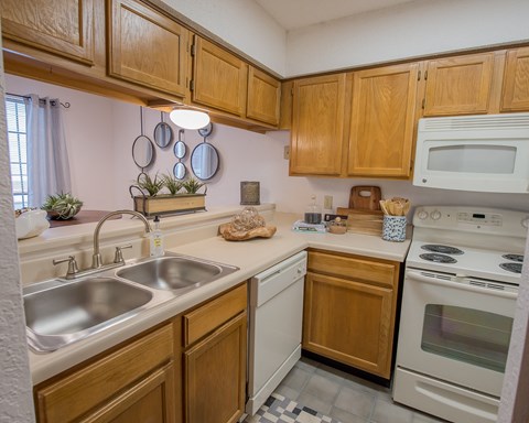 A kitchen with wooden cabinets and a white oven.