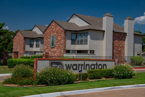 The Warrington sign is in front of a brick building.