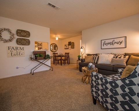 A living room with a sofa, a table, and a mirror.