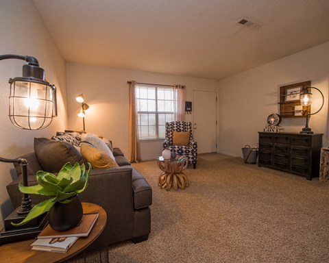 A living room with a couch, coffee table, and a lamp.