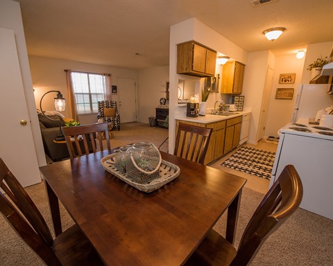 A dining room with a wooden table and chairs.