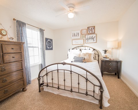 A bedroom with a large bed, a dresser, and a nightstand.