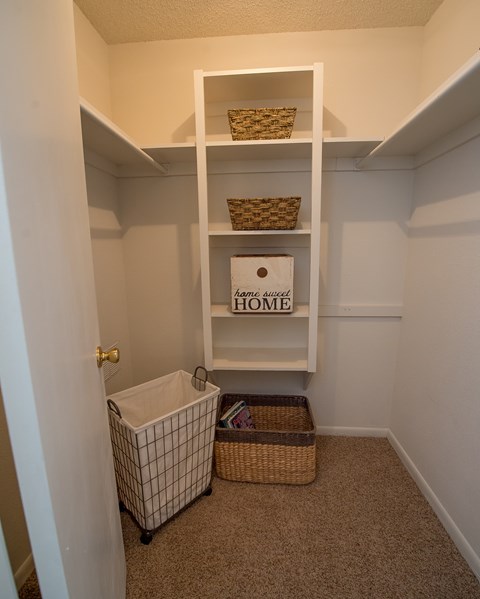 A small white closet with a shelf and a basket.