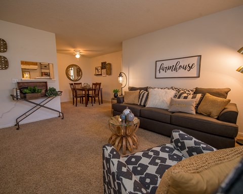 A living room with a couch, a coffee table, and a fireplace.