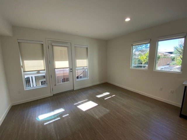 Living room with wood flooring and windows.
