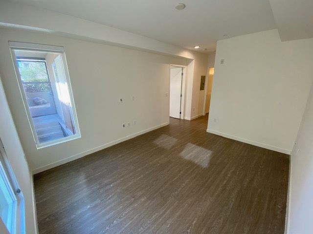 Bedroom with wood flooring and windows.