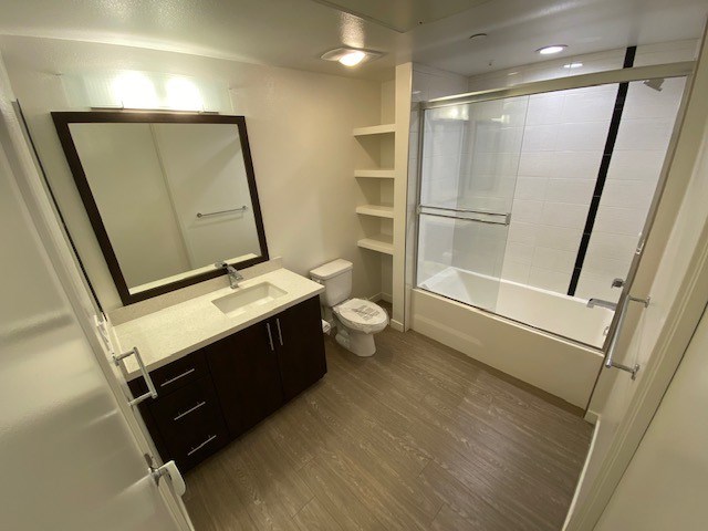 Bathroom with a toilet, sink, mirror, and shower/bathtub.