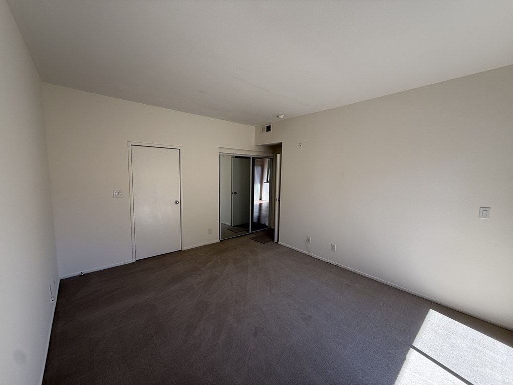 Bedroom with carpet floors, closet with mirror doors.