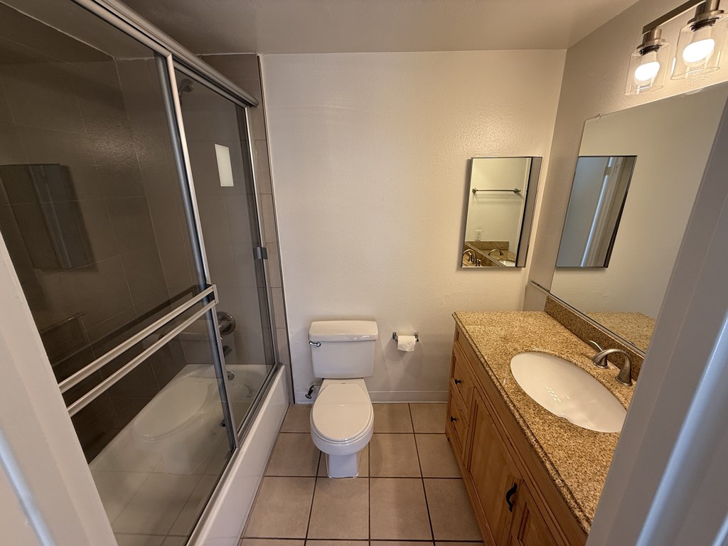 Bathroom with a toilet, sink, a mirror and shower/tub.