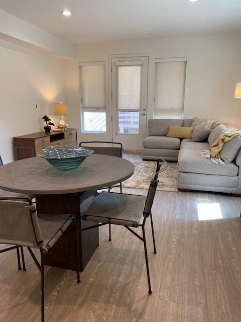 Modern living room and dining area with a table, chairs and sofa.
