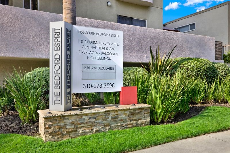 A sign for The Bedford Esprit apartment complex lists the amenities.