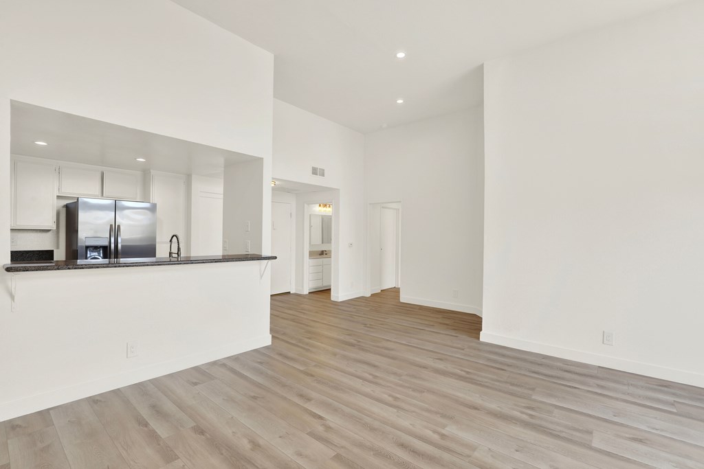 A spacious kitchen with white cabinets and a refrigerator.