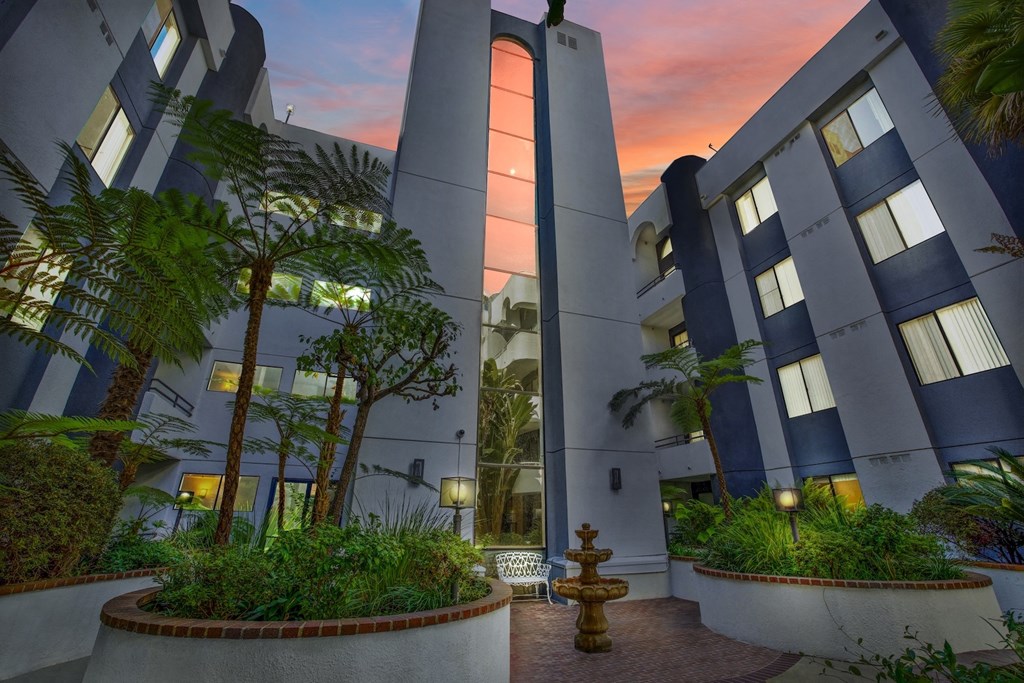 A modern building with a courtyard and a fountain at dusk. at Midvale Court, Los Angeles