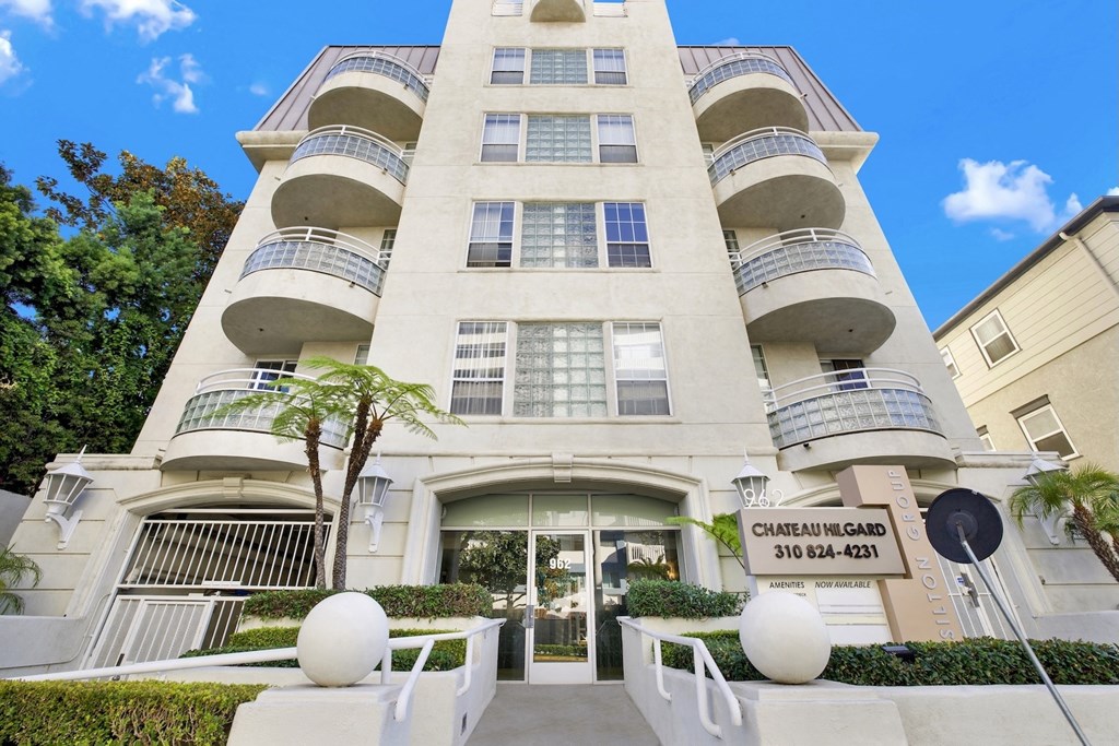 Entrace view of apartment building with a sign that reads Chateau Hilgard 310 824-4231.