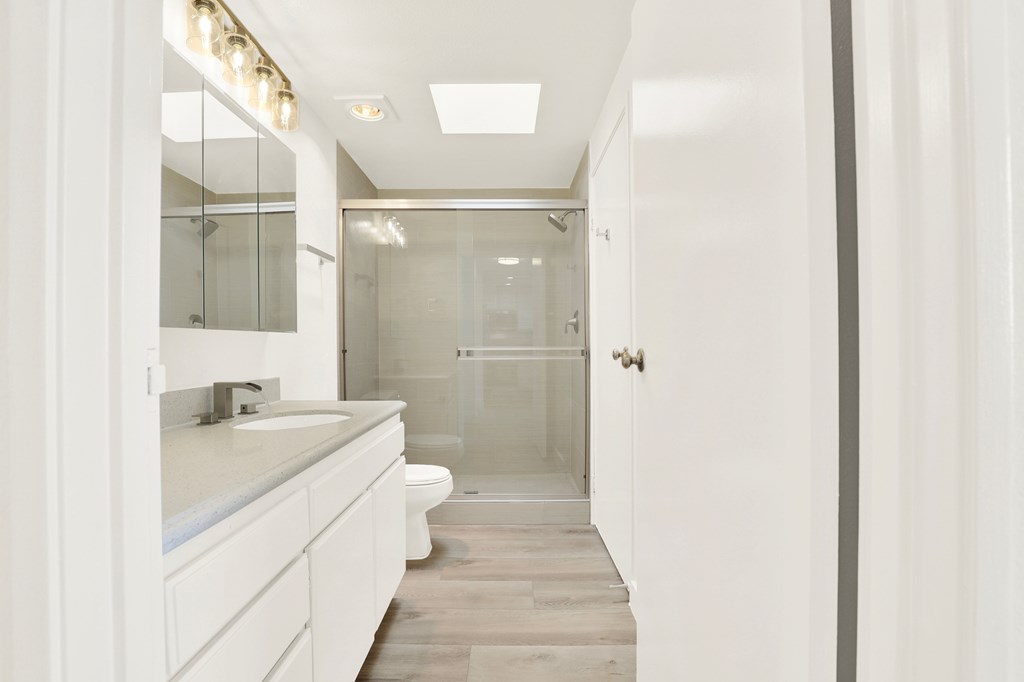A white bathroom with a walk in shower.