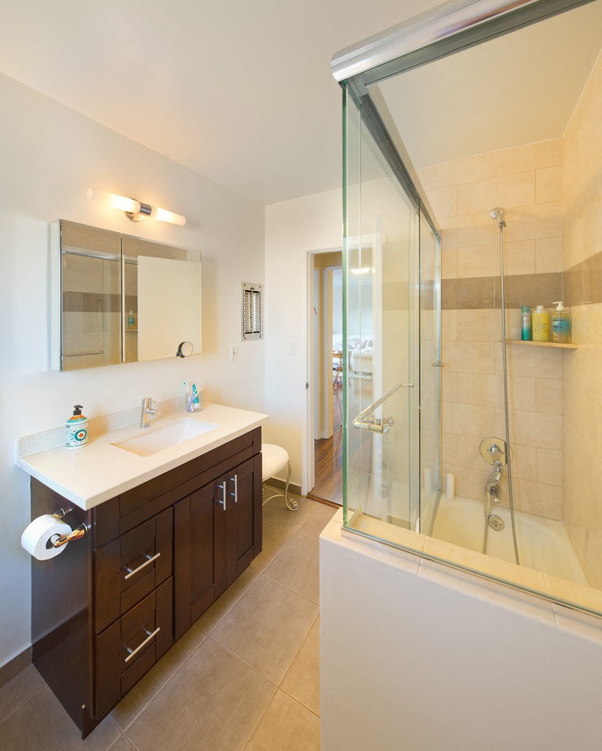 Apartment bathroom with vanity, shower tub combo