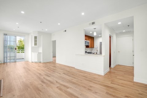 a living room with white walls and a wooden floor