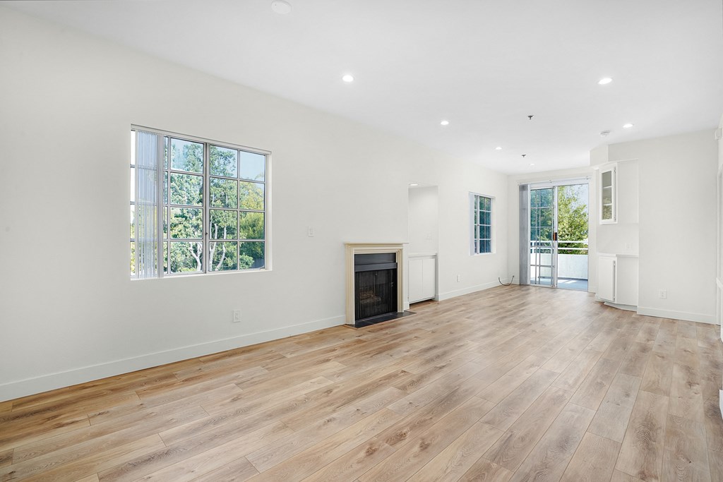 Apartment living room with fireplace, built-in cabinets and balcony.