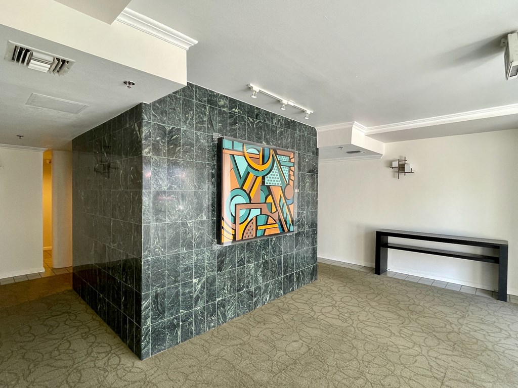 Lobby with emerald colored tile wall with abstract painting
