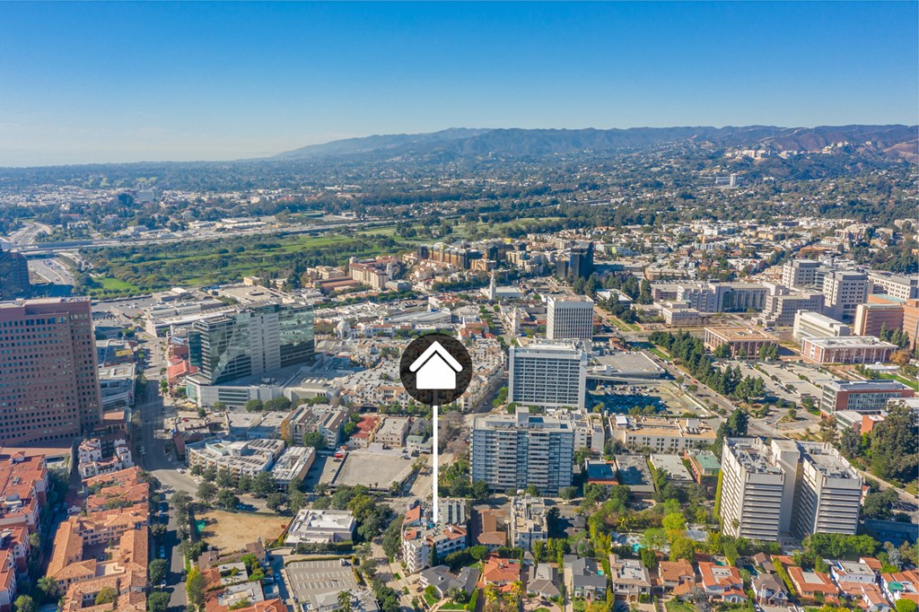 Aerial view of buildings and homes with property identification marker