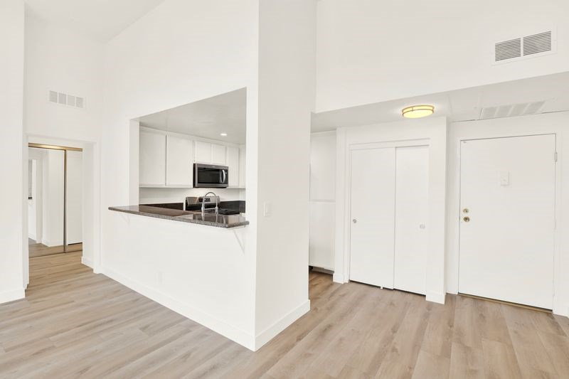 A kitchen with white cabinets and a microwave.