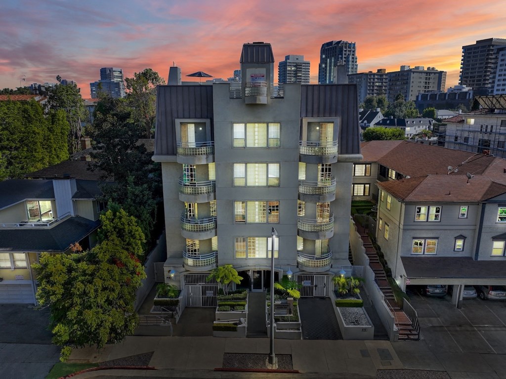 Exterior aerial view of apartment building at dusk.