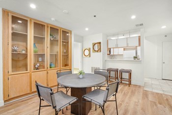Apartment dining room area with a circular table with four chairs and built-in cabinets.